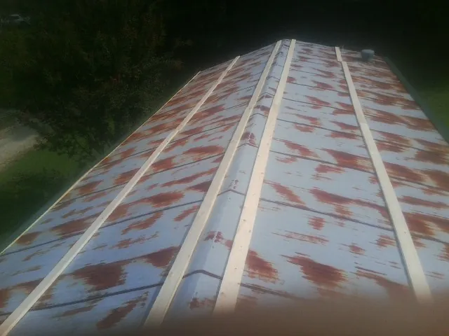 Rusted metal roof panels with new wood purlins before replacement — Storm Damage Roof Repair in Douglas by Roofing Brothers