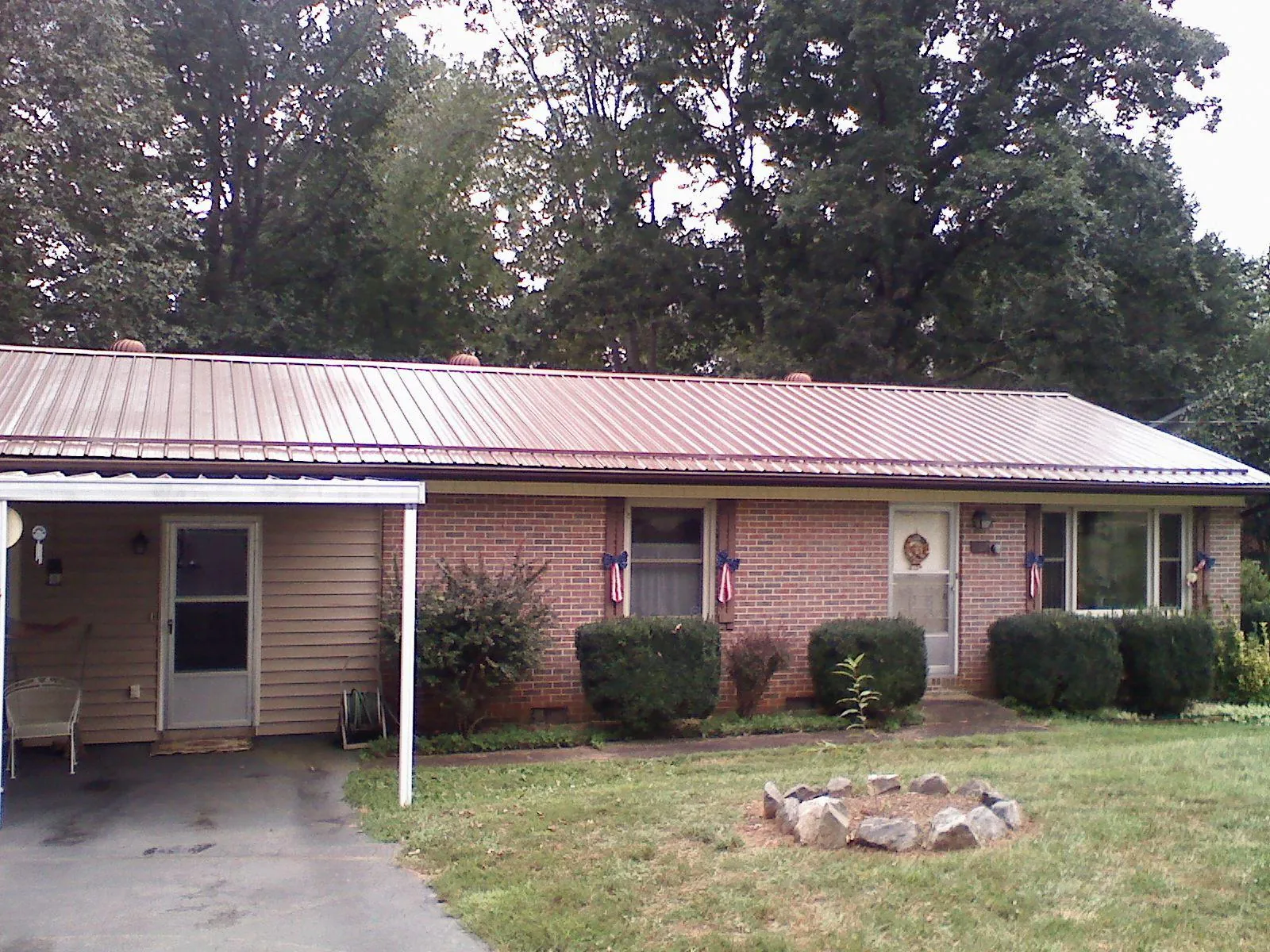 Bronze metal roof and carport on a brick ranch home — Roof Repair work by our crew in Douglas